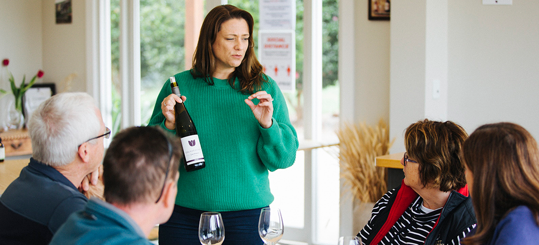 Woman explaining a wine to a group of people